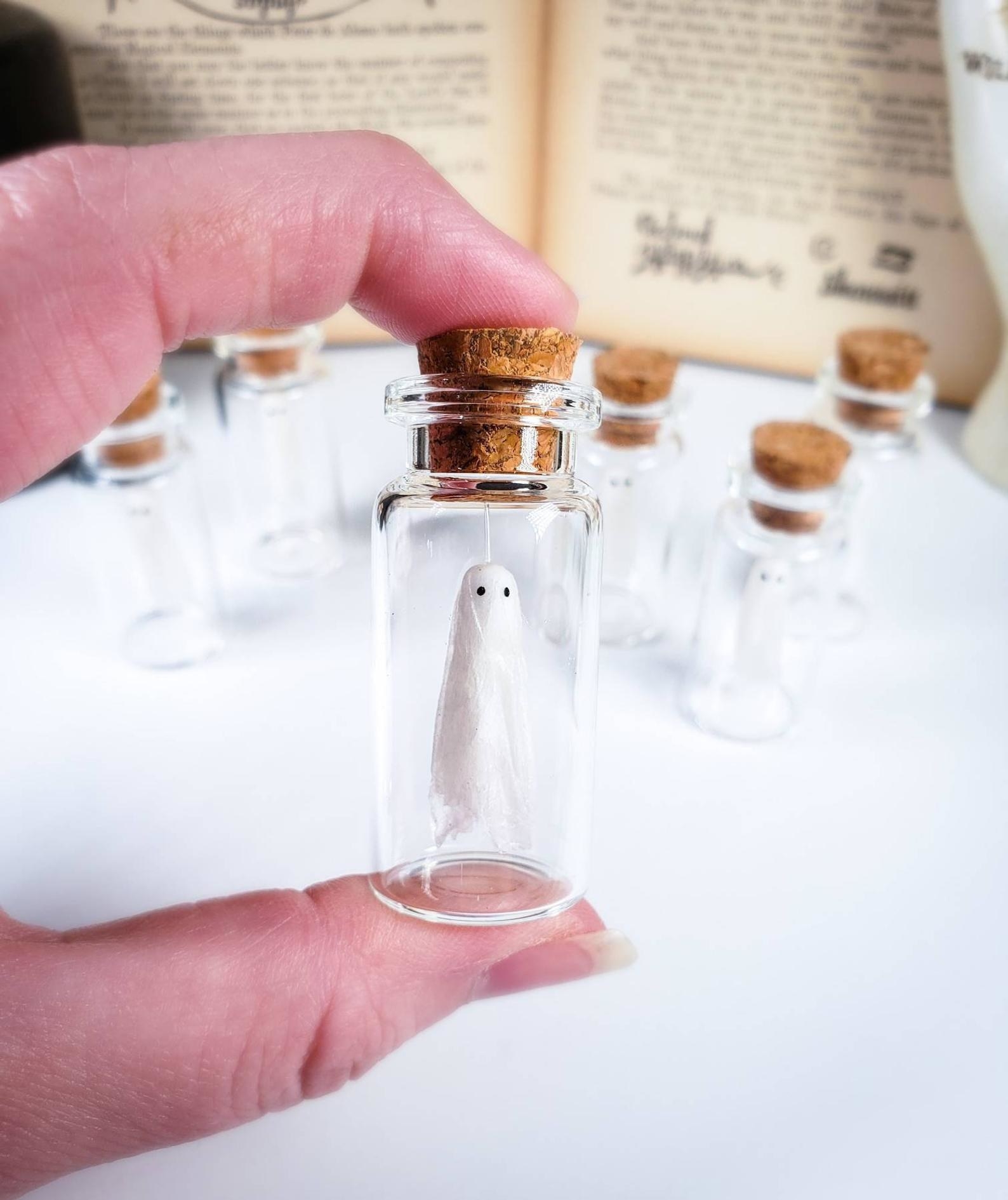 a tiny ghost hanging in a tiny jar