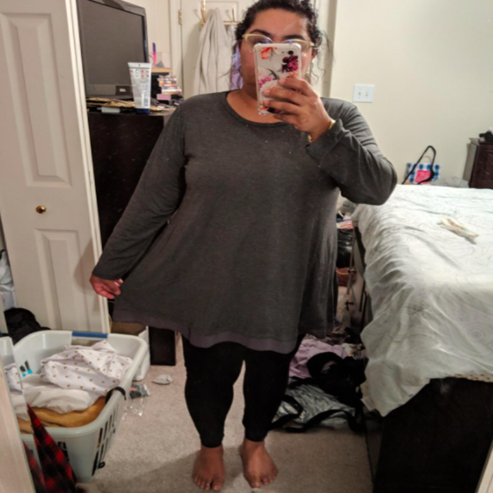 A reviewer wearing the top in gray