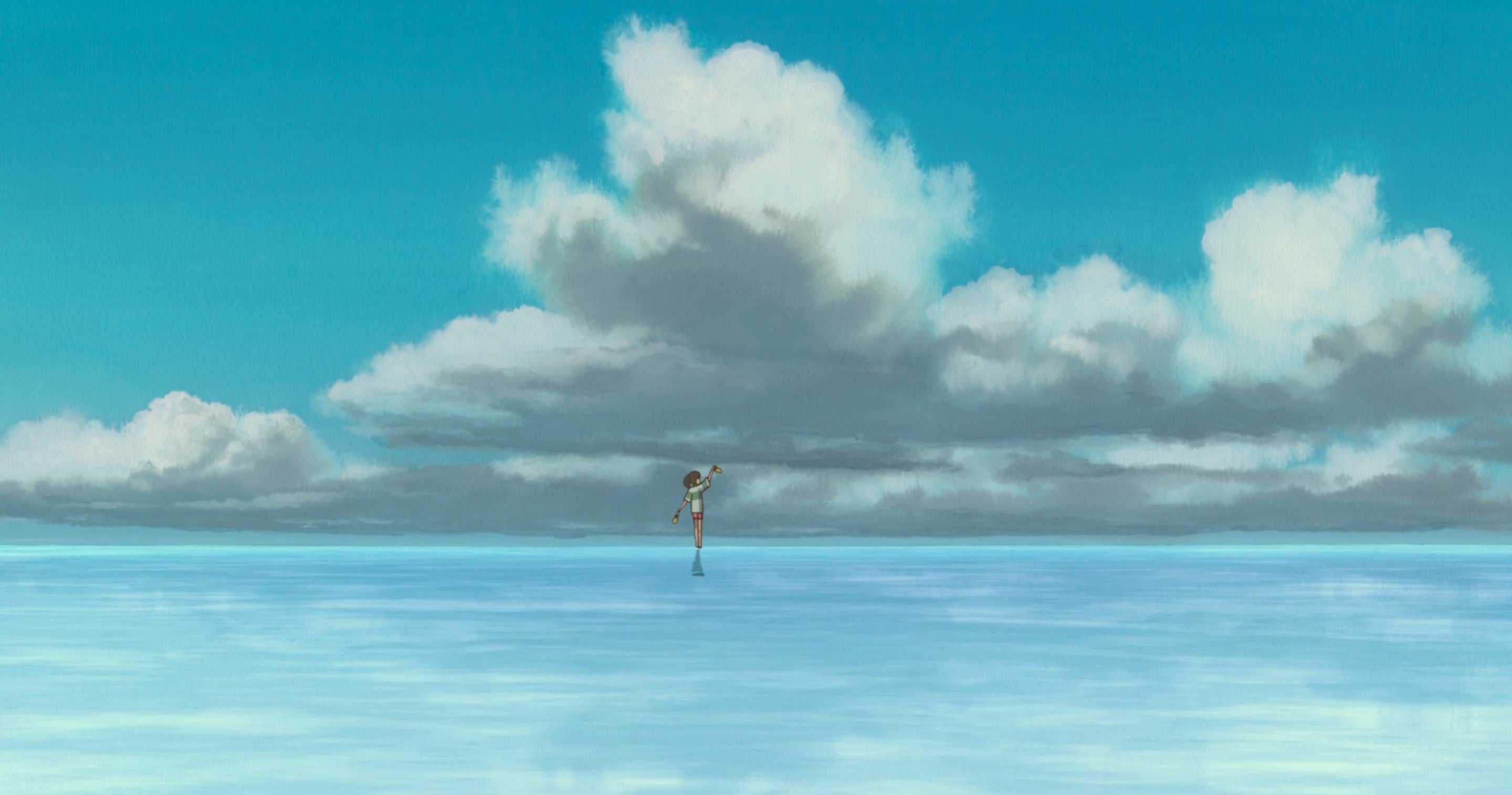 A girl walking on shallow water with large clouds above her