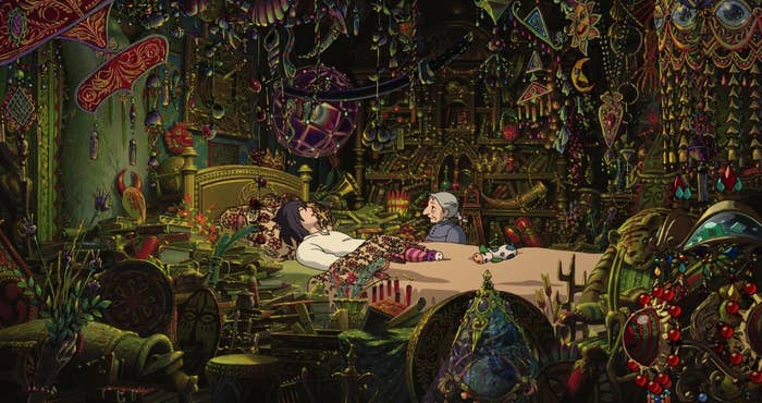 A man in a bed with an old woman sitting next to him, in a room full of sparkling knickknacks