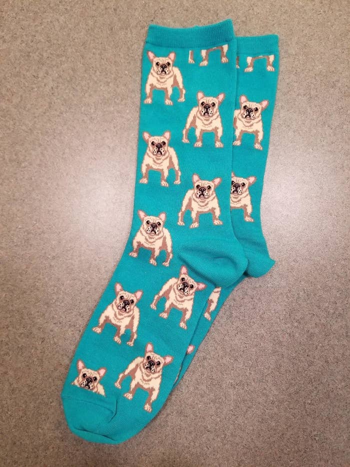 Reviewer pic of the teal socks with illustrations of yellow Frenchies all over them