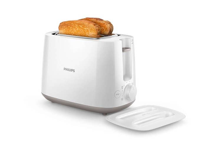 A white toaster with 2 pieces of toast in it