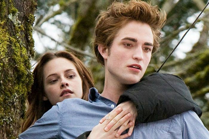 Bella sitting on top of Edward&#x27;s back as they&#x27;re in the forest