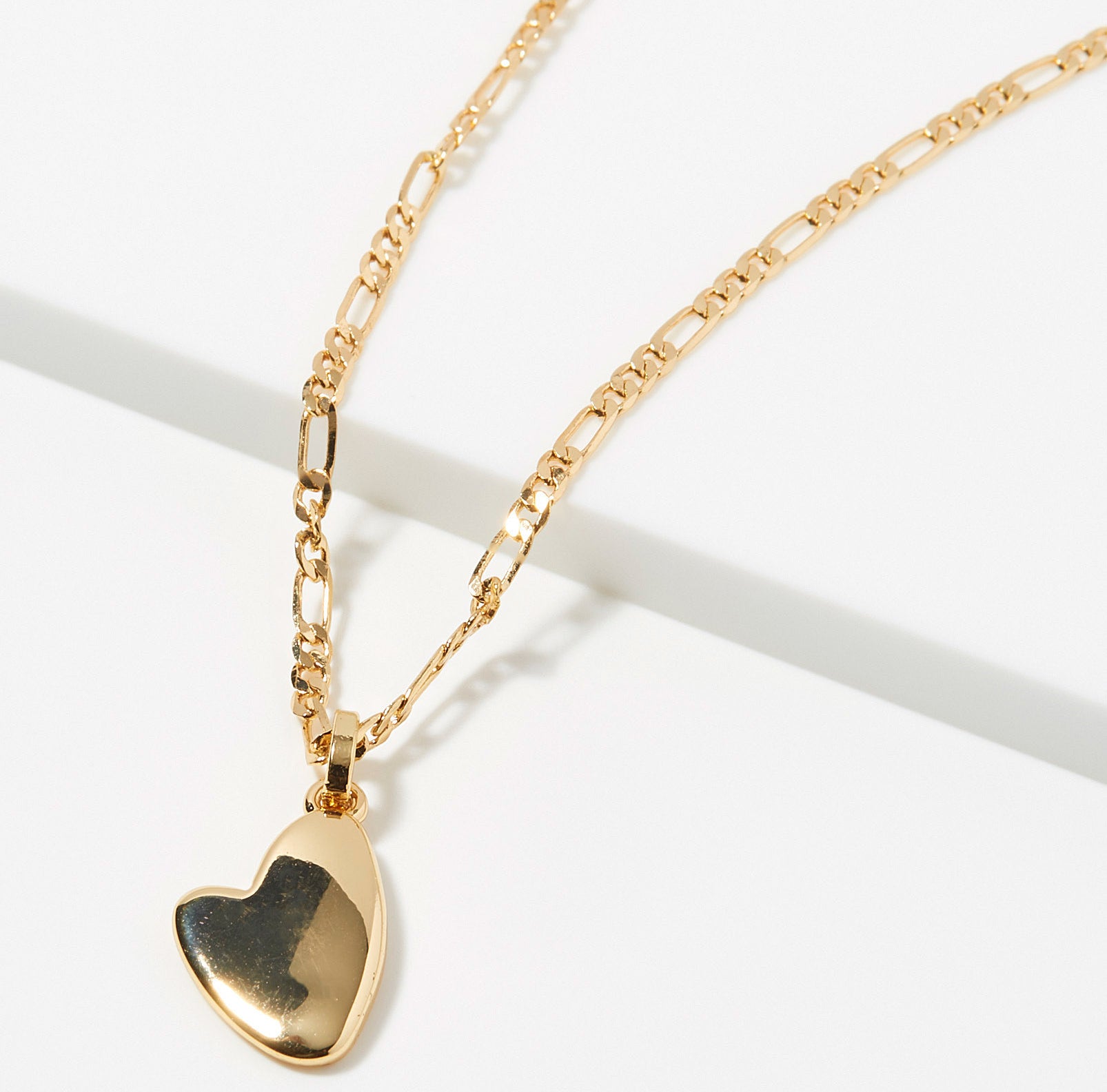 A gold chain necklace with a heart-shaped pendant