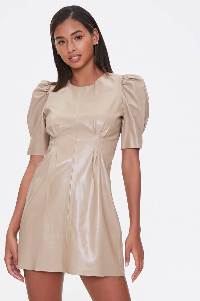 A model wearing the short-sleeve dress with dart details on the bodice in tan