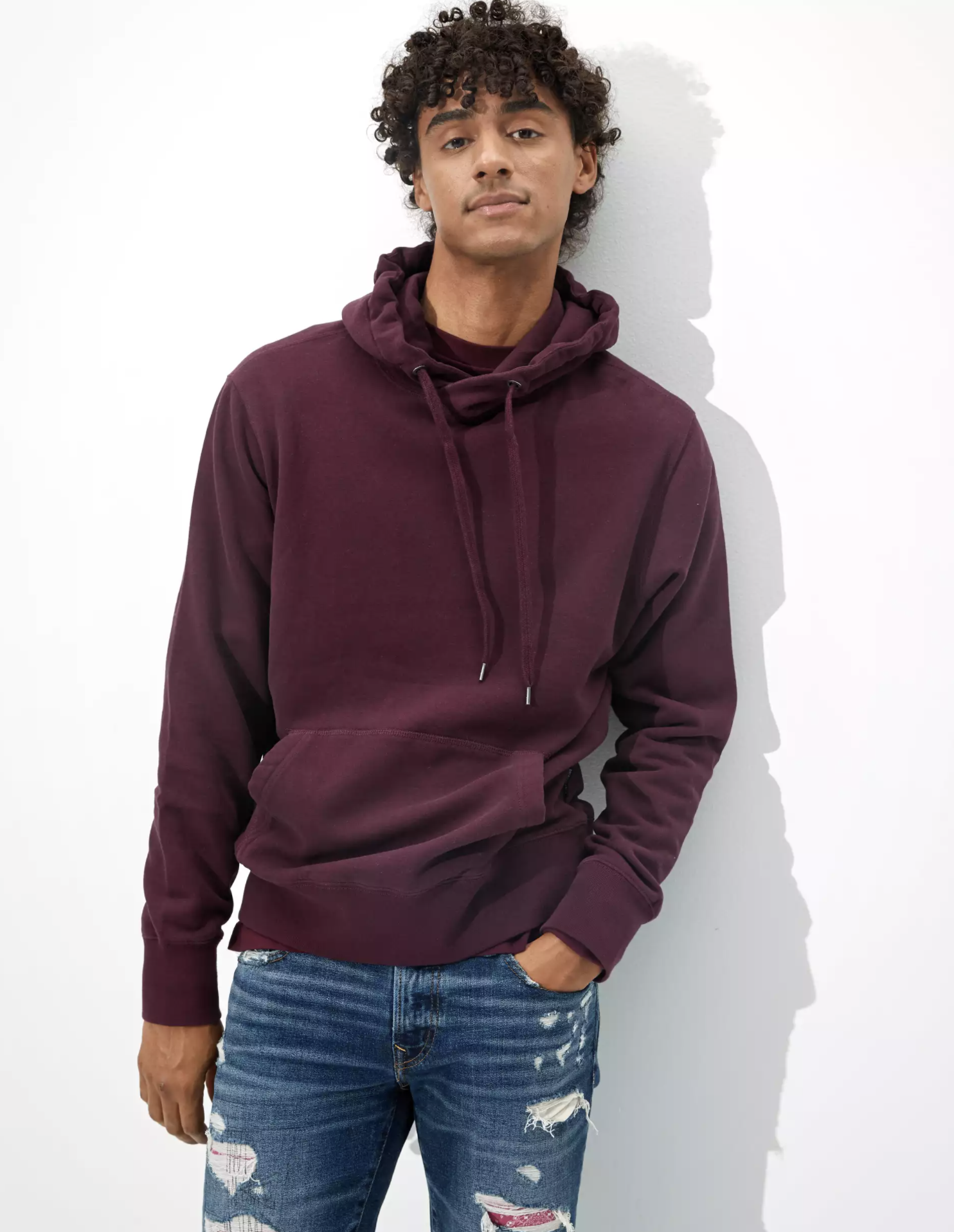 A model wearing the maroon hoodie
