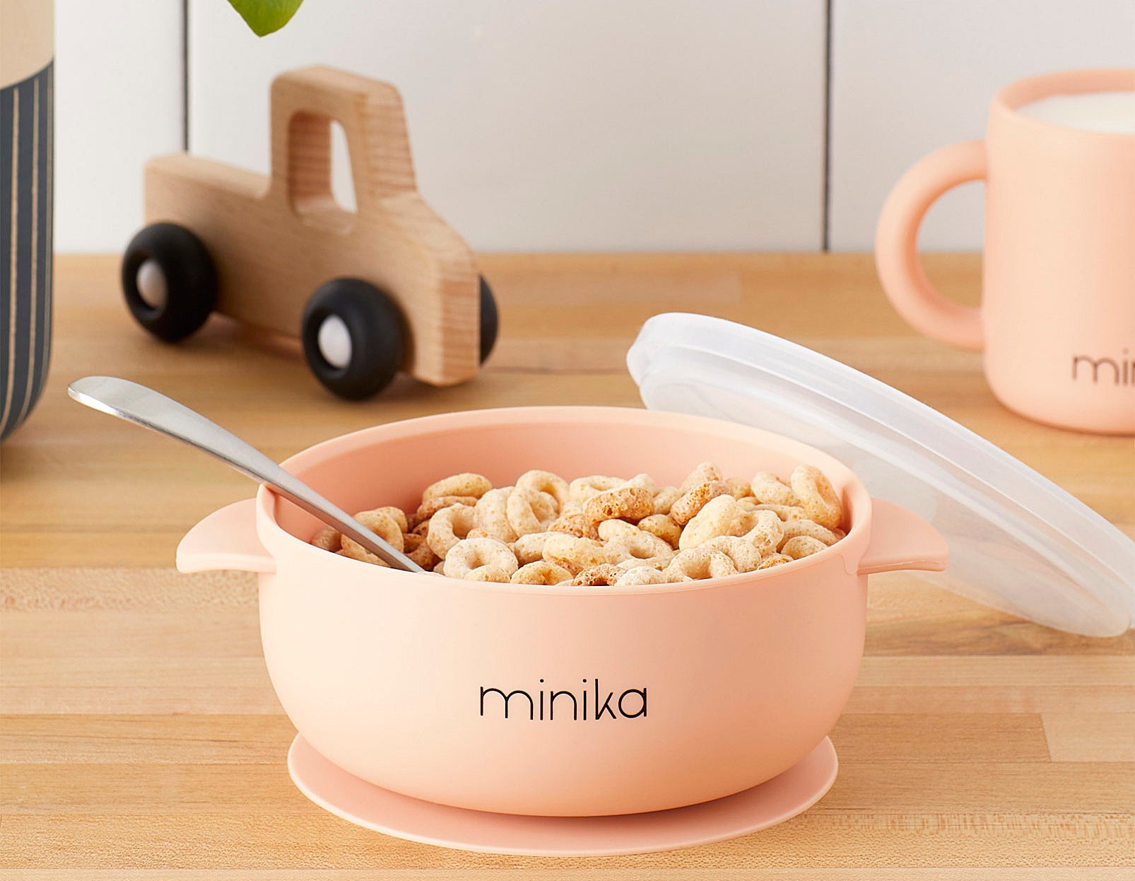 A small silicone bowl stuck to a wooden table and filled with Cheerios