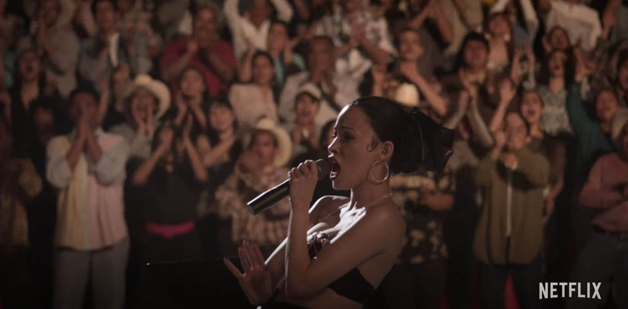 Christian Serratos as Selena performing in front of a large crowd