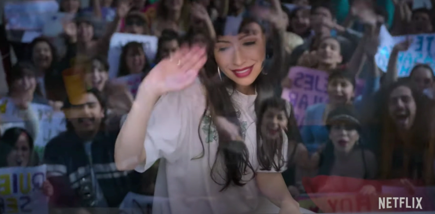 Christian Serratos as Selena waving to a crowd of fans