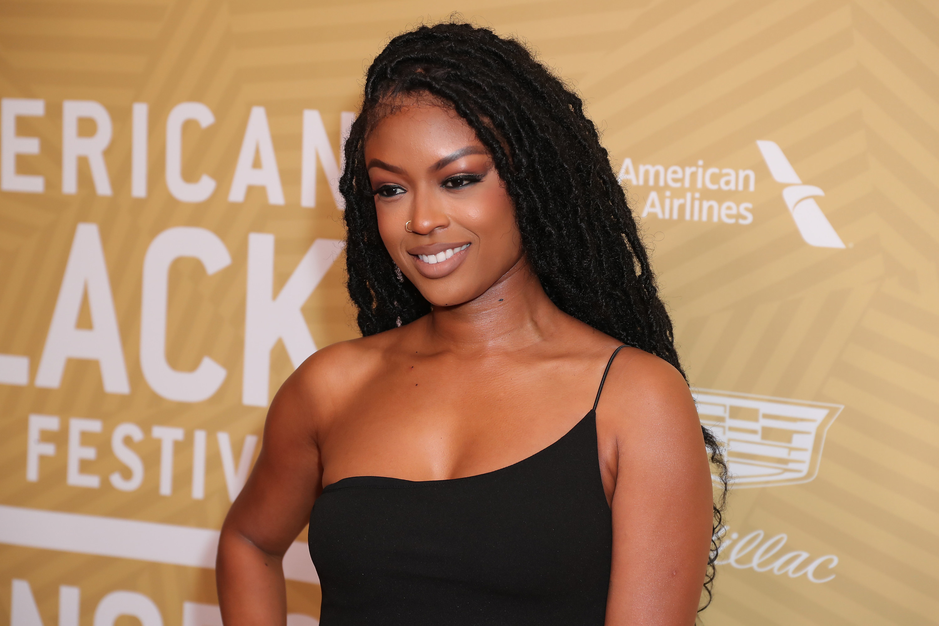 Javicia Leslie smiles as she poses on a red carpet 