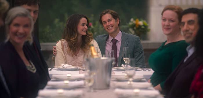 Wedding guests smiling as they sit around a long table