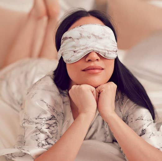A person wears a sleep mask in bed