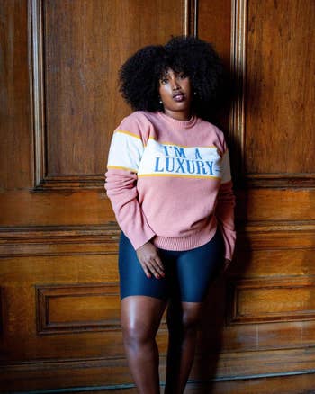 a model wearing a pink sweater with the words 