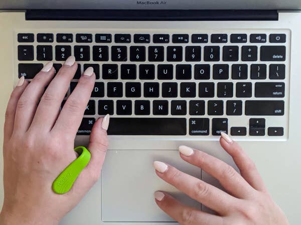 A top down shot of a person typing on their keyboard while wearing the acupressure tool