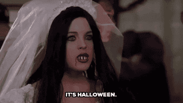A girl dressed up in a scary Halloween costume saying &quot;It&#x27;s Halloween&quot;