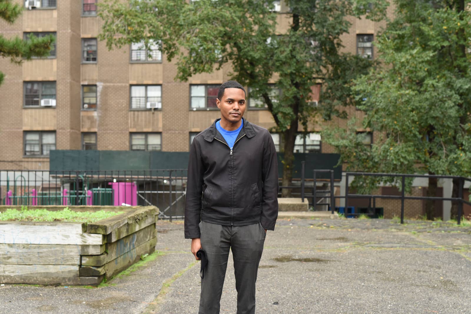 Torres stands in front of a housing project