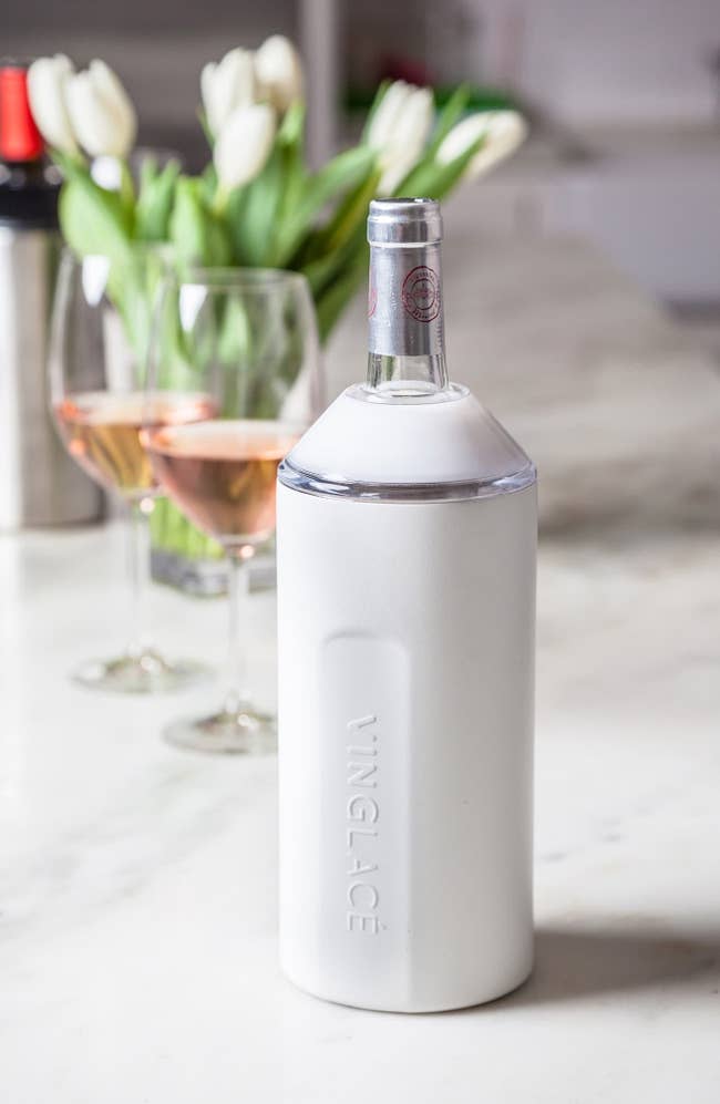The white chiller with a wine bottle in it, keeping it cold