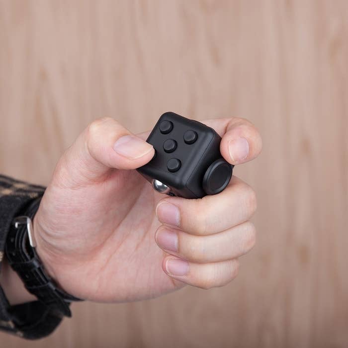 A person with the fidget cube in their hand.
