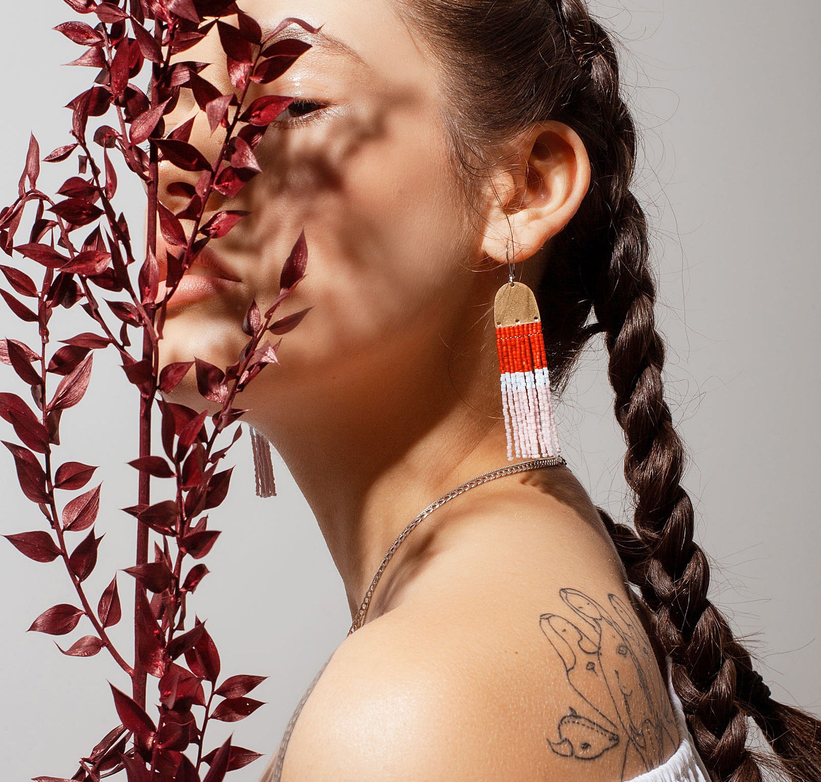 A person wearing long beaded earrings