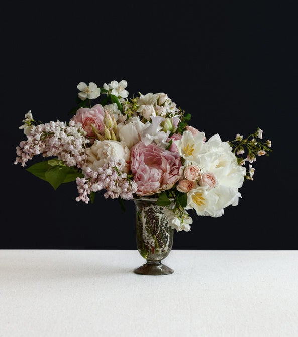 A bouquet of fresh flowers in white and pink in a black vase