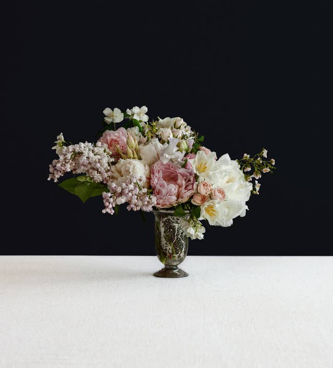 A bouquet of fresh flowers in white and pink in a black vase