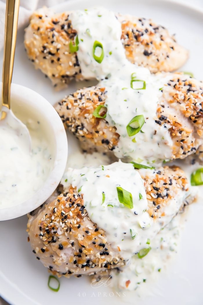 Three pieces of everything bagel-seasoned chicken breast with scallion cream cheese sauce
