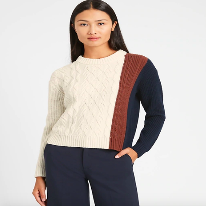 Knit sweater in white from chest to sleeve and blue and brown on other sleeve 