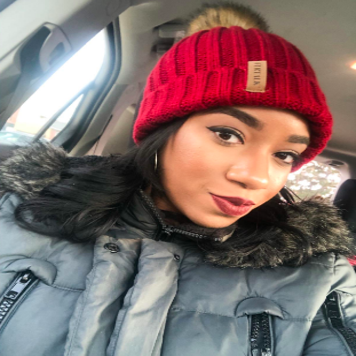 Different reviewer wearing hat in red with brown pom pom