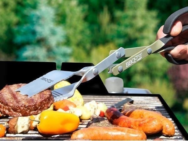 A person flipping a burger on the grill with the BBQ tool