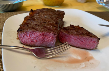 A reviewer showing the inside of their perfectly cooked steak