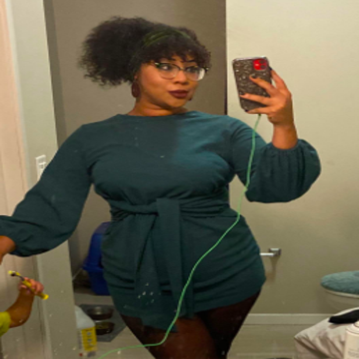 Reviewer wearing dress with balloon sleeves and wrap tie around waist. It hits at the collarbone and is a mini cut.