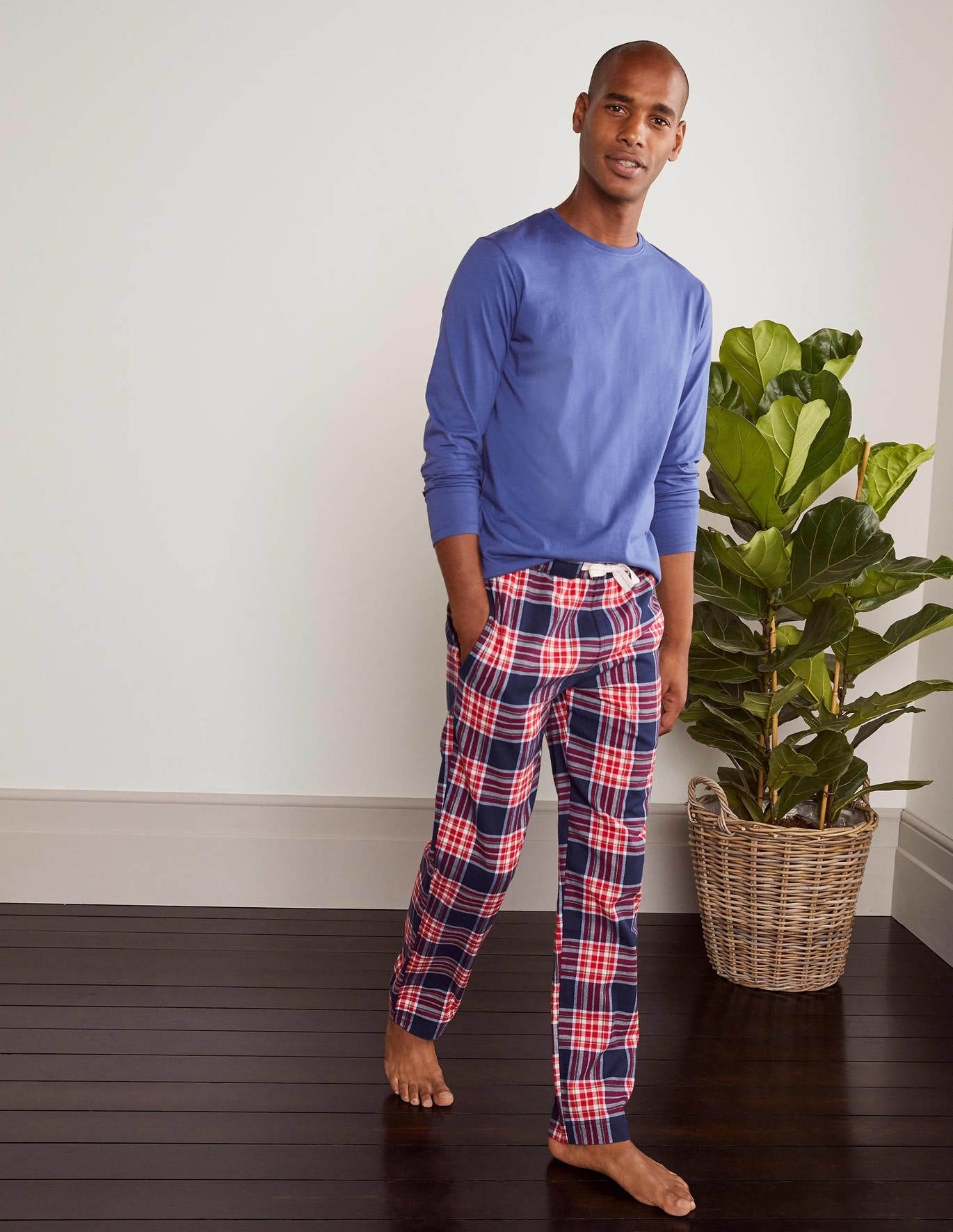 Model wearing the full-length pajama bottoms with an elastic waist in red and blue plaid