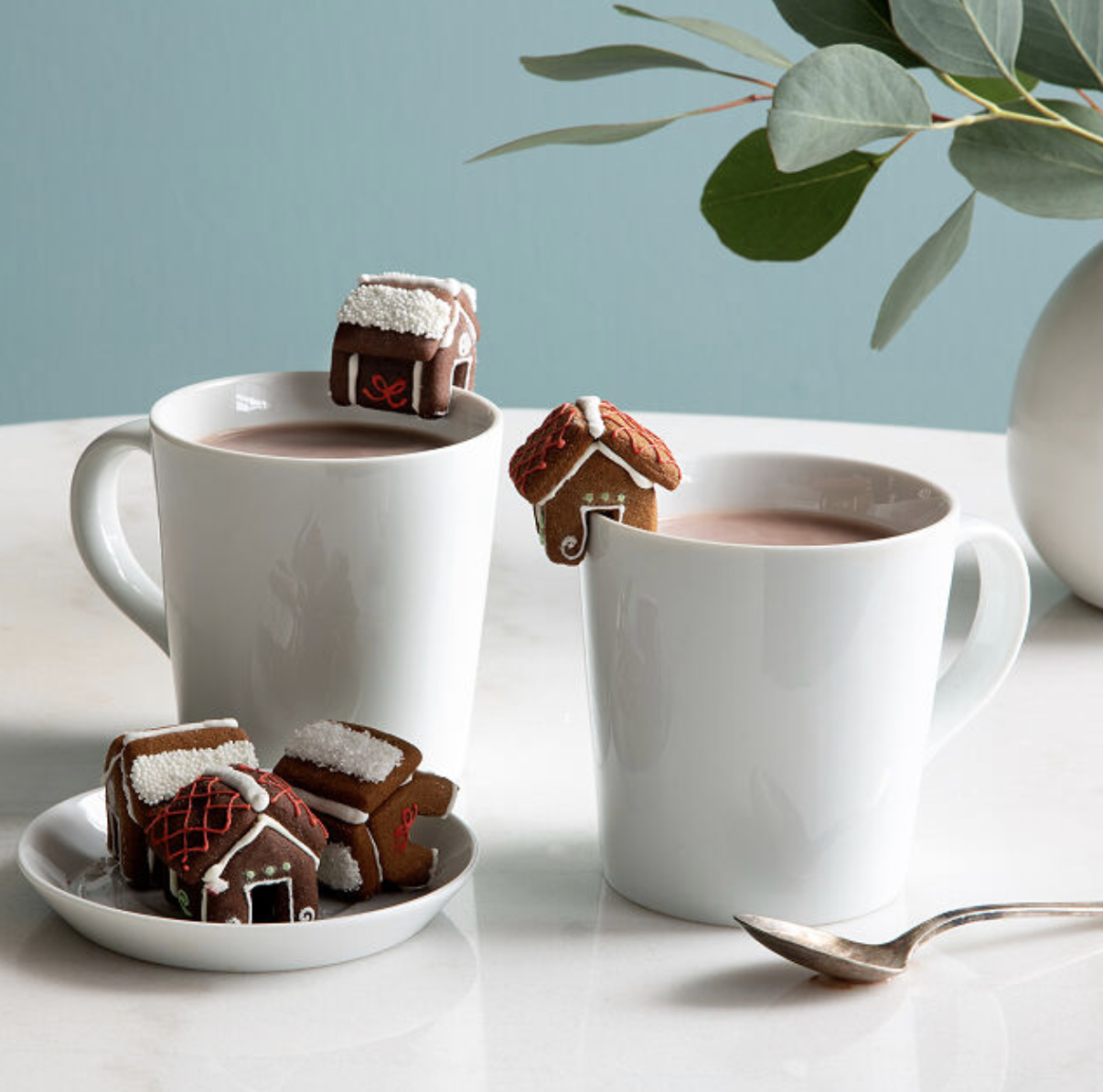 mugs that have little gingerbread houses perched on the lip of them