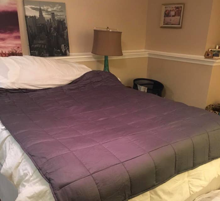 A dark gray weighted blanket on top of a reviewer&#x27;s bed