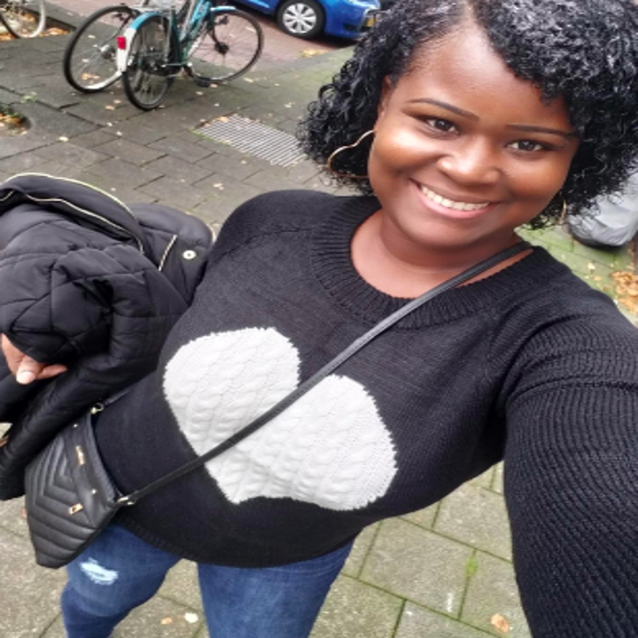 Reviewer wearing sweater in black with large white heart in center 