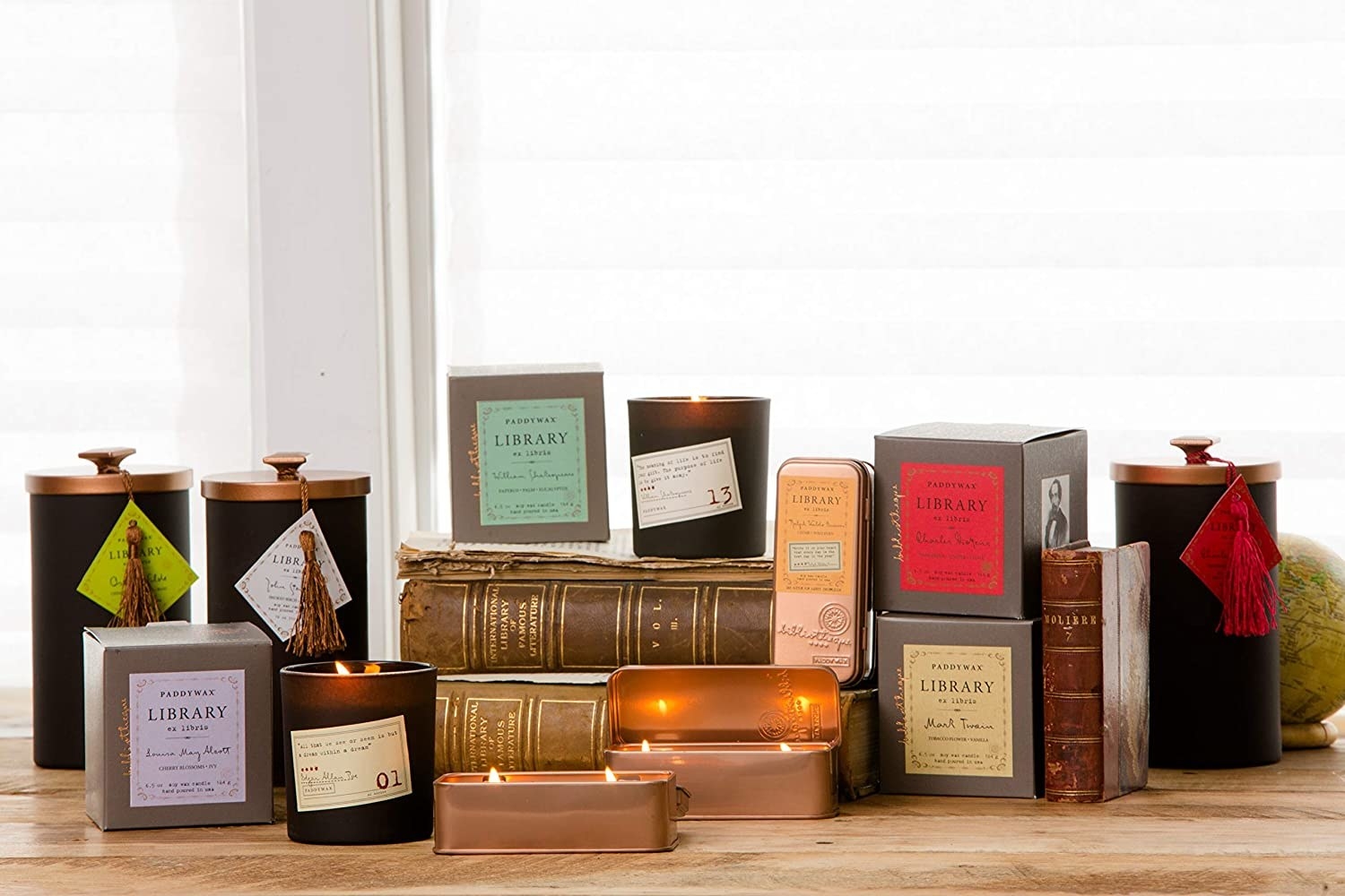 the line up of all the candles in the collection which have dark glass and vintage looking book labels on them