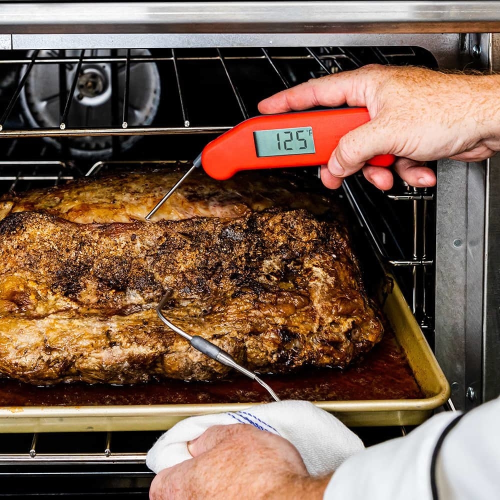 Inserting an instant-read thermometer into a cut of meat.