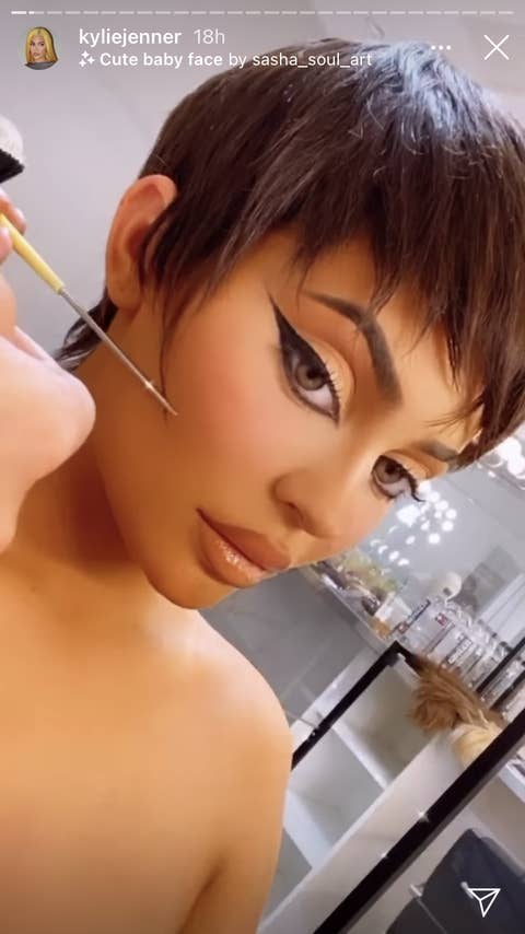 Kylie as the someone puts the finishing touches on her wig