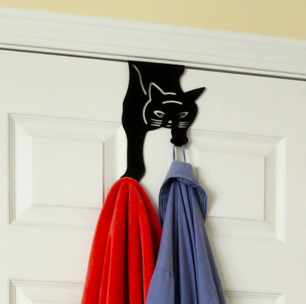 Black cat over-the-door hanger holding up a red towel and a blue shirt