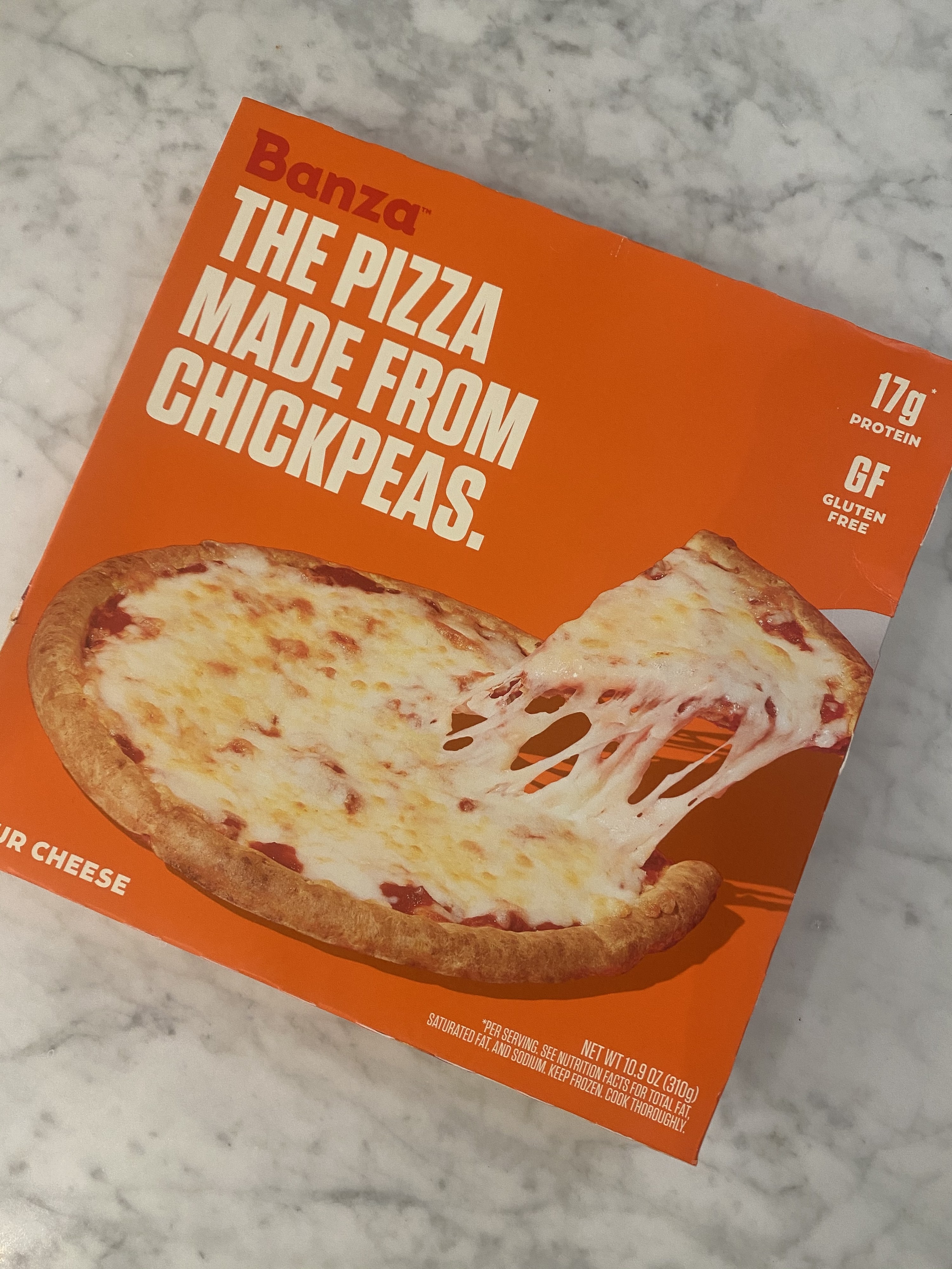 The front of a box of Banza four cheese chickpea crust pizza.