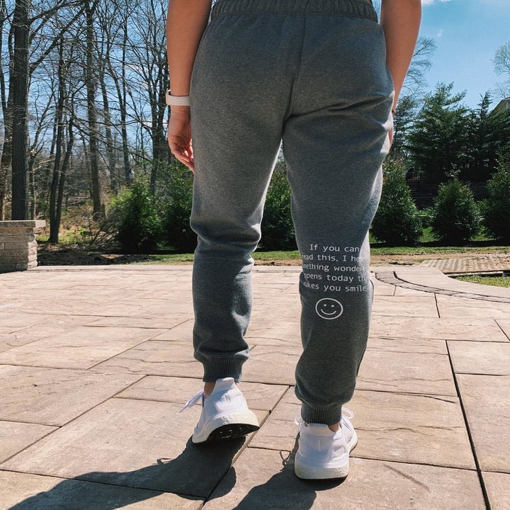 Back of gray leggings with phrase written on inner right knee