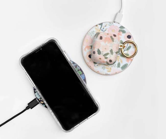 Two circular chargers in floral prints with a phone on one and AirPods on the other