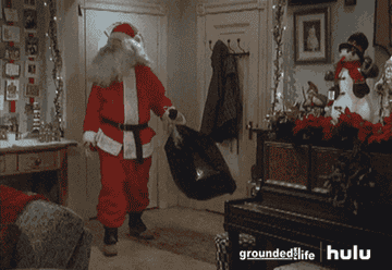 Santa walking into house and dumping gifts out of a garbage bag