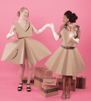 Two models dancing in dresses made from Amazon boxes
