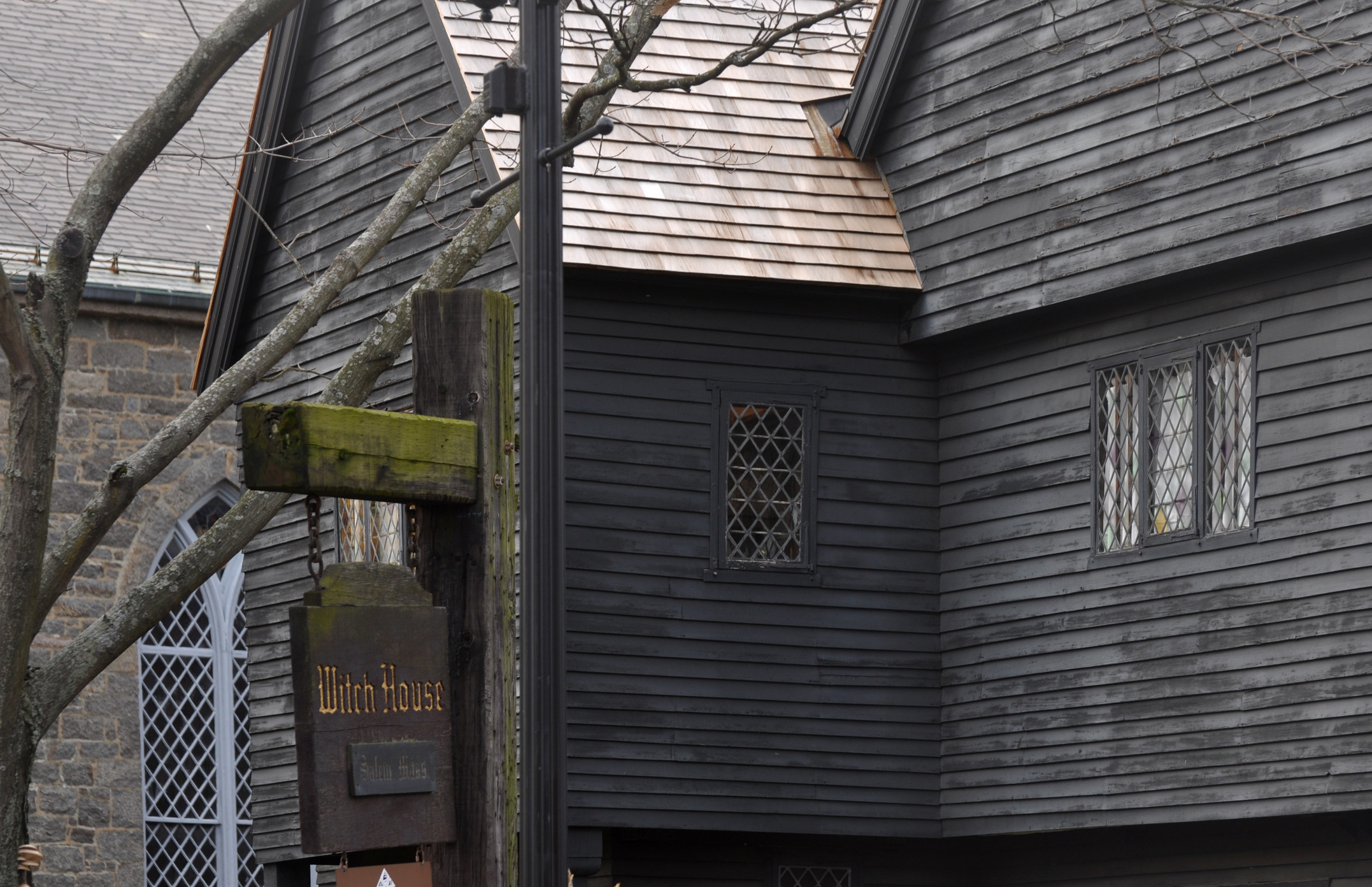  old black weatherboard historical house in Salem with sign reading &quot;Witch House&quot;