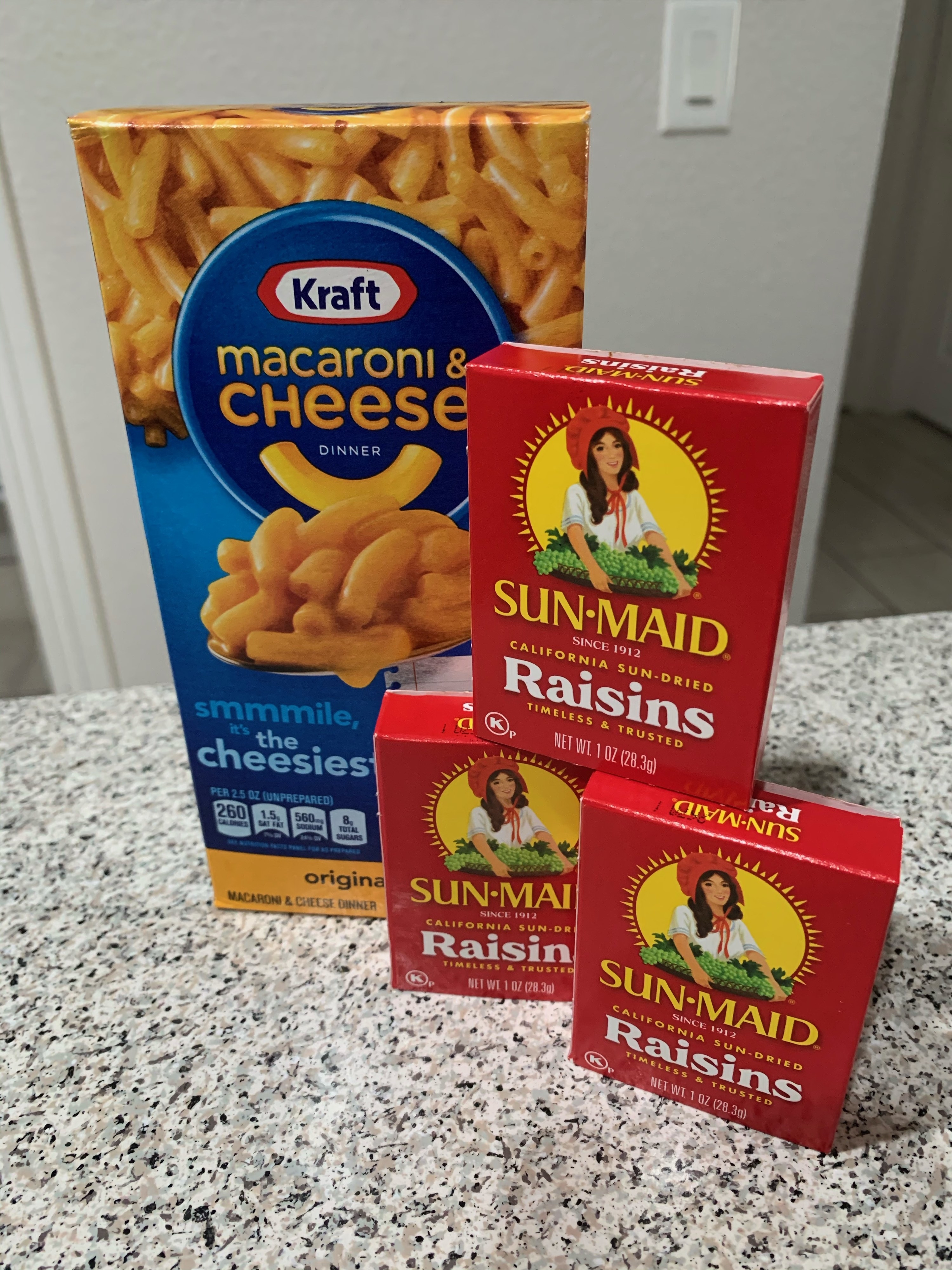 A box of Kraft Macaroni &amp;amp; Cheese and three Sun-Maid Raisins