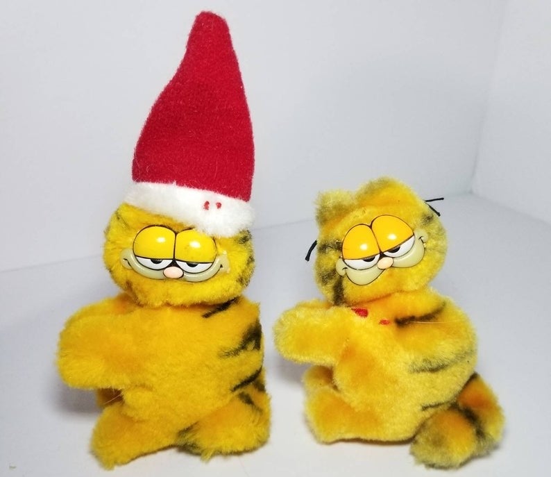 Two small Garfield hugger toys one wearing a Santa hat