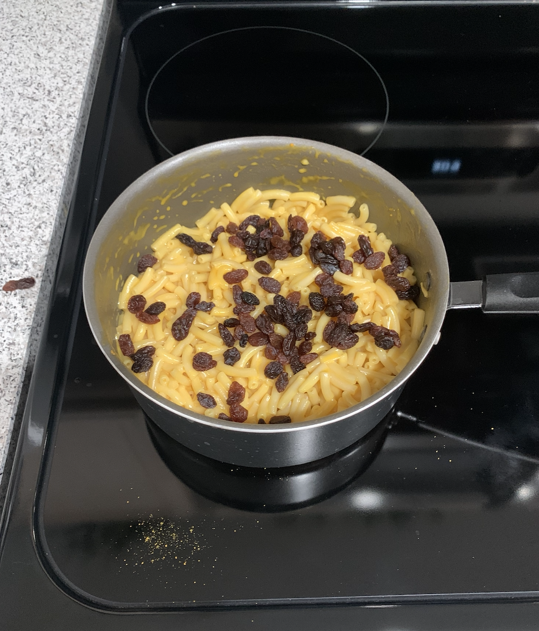 Questionable pot of macaroni and cheese topped with raisins