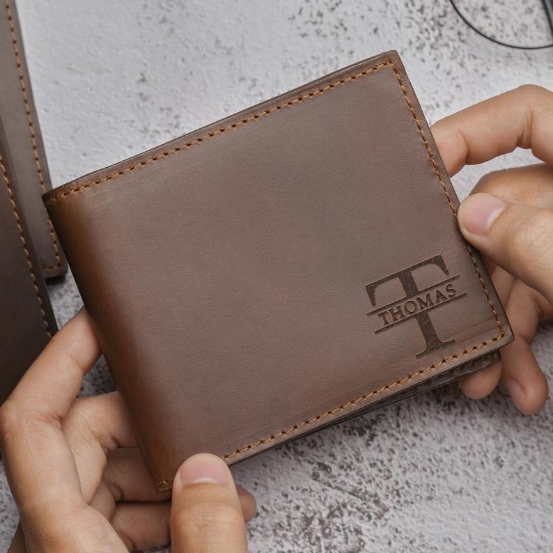 hands holding an engraved wallet 