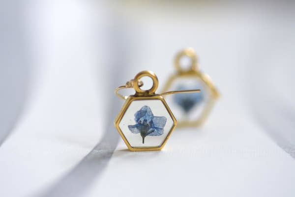 the hexagon earrings with a small pressed blue flower in the center